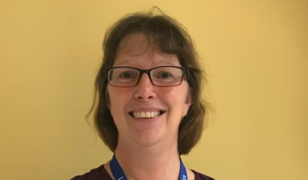 a person wearing glasses and smiling at the camera