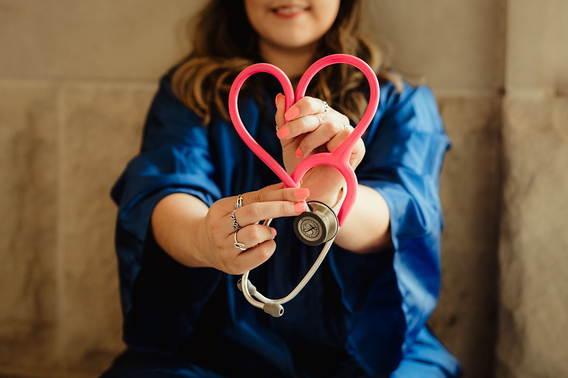 a nurse holding a stethocope shaped like a heart
