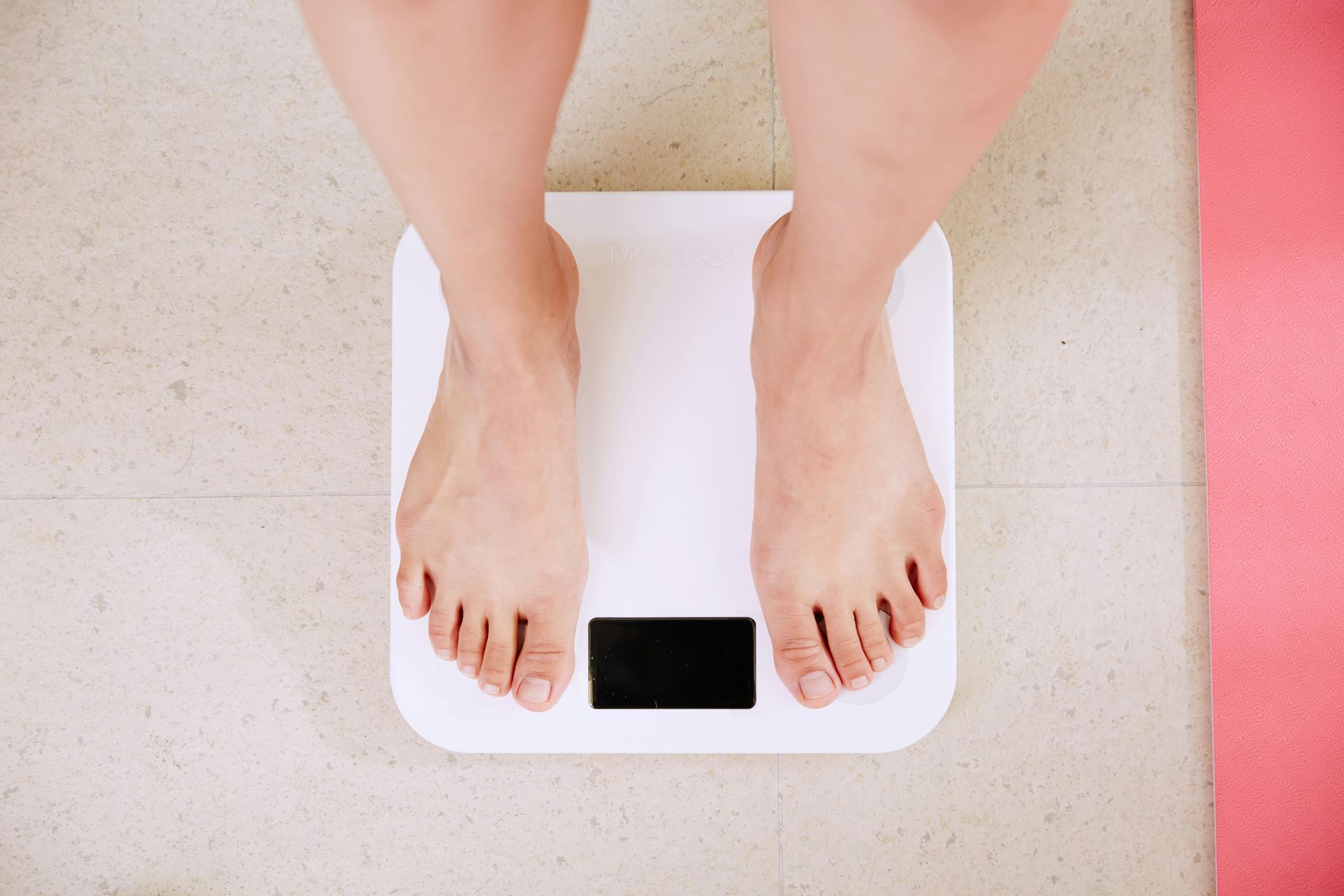 the legs and feef of a person stood on weighing scales