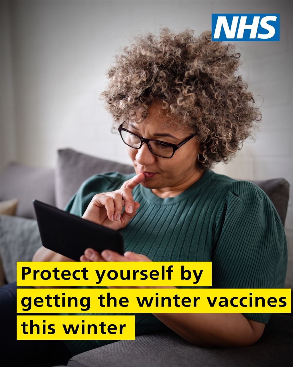 a woman looking at a tablet, a thoughtful look on her face, the NHS logo and the words Protect yourself by getting the winter vaccines this winter